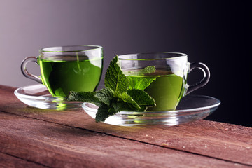 cups of tea with mint on wooden table