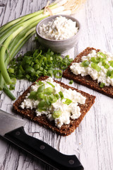Cream Cheese on a slice of bread topped with fresh green onions