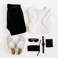 Male trendy fashion clothes and accessories collage on white background. Flat lay, top view. Jeans, sneakers, wallet, shirt, sunglasses, watch.