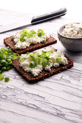 Cream Cheese on a slice of bread topped with fresh green onions