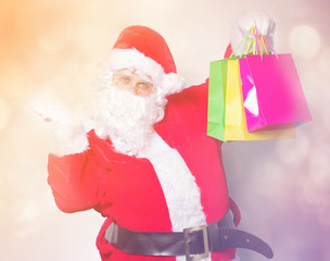 Funny Santa Claus have a fun with shopping bags on blue background