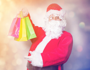 Funny Santa Claus have a fun with shopping bags on blue background