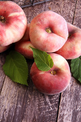 Ripe peaches in basket on wooden background