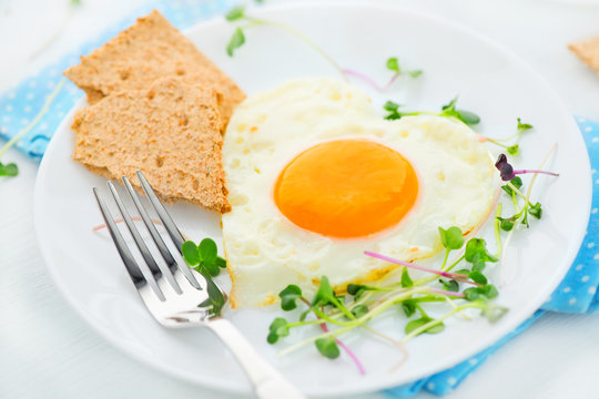Healthy breakfast. Fried heart shaped egg closeup