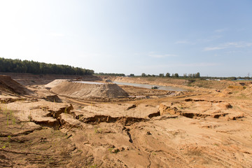 Mining in a sand quarry with powerful machines and a washing lake