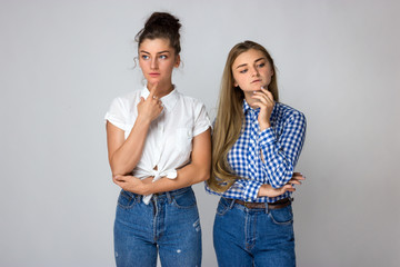 Naklejka premium Two young sisters thinks