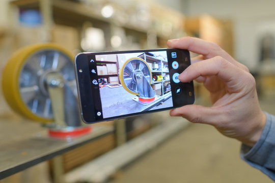 close up handholding smartphone and take photo of a wheel