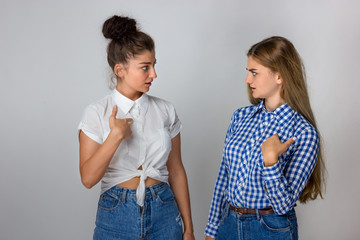 Beautiful smiling two young sisters shows a finger on the are you talking to me