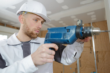 contractor uses hammer drill to drill the concrete wall