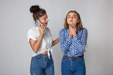 Young woman with sore throat her sister calls a doctor.