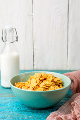Bowl with oat flakes on a blue wooden table.