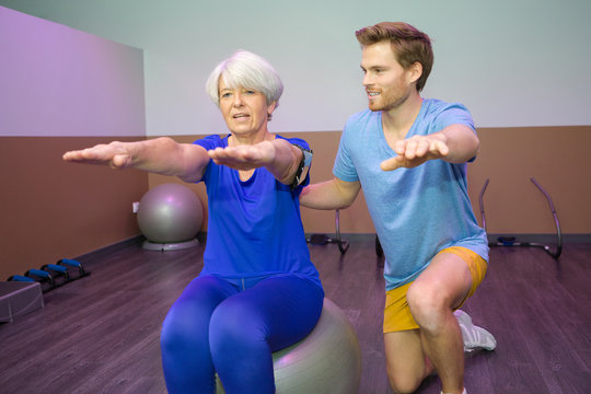 old woman doing physical therapy on the ball