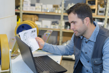 man working with new laptop and checking instructions