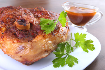 grilled pork chop with sauce on wooden table.