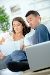 couple with financial documents and laptop