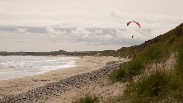 Para-glider flies at the beach