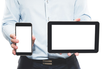 Businessman with elegant clothes holds black tablet and black cellphone with blank screen isolated...