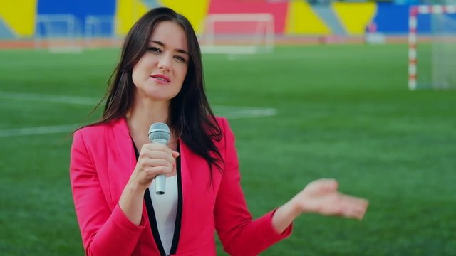 Young girl TV reporter is broadcasting from stadium