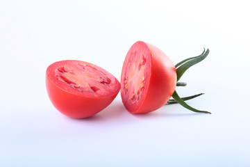 sliced fresh tomatoes with green leaves isolated on white background