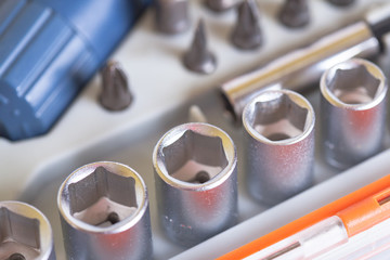 Heads under the nut. Metal bits and flat-head screwdriver. Tool kit for home use. Nozzles and...