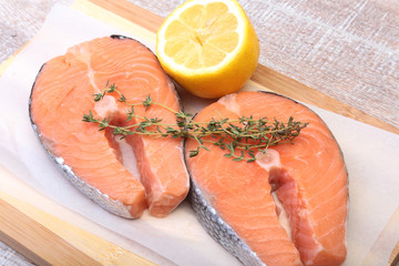 fresh raw salmon with spices and lemon on wooden cutting board. ready for cookin