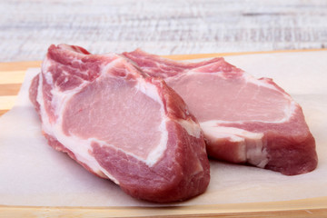 Raw pork chops, spices on cutting board. Ready for cooking.