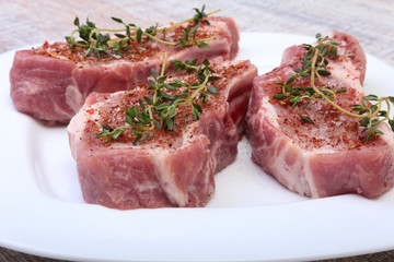 Raw pork chops, spices and rosemary on cutting board. Ready for cooking.