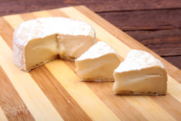 Cheese with white mold. Camembert or brie type on wood table. Healthy breakfast.