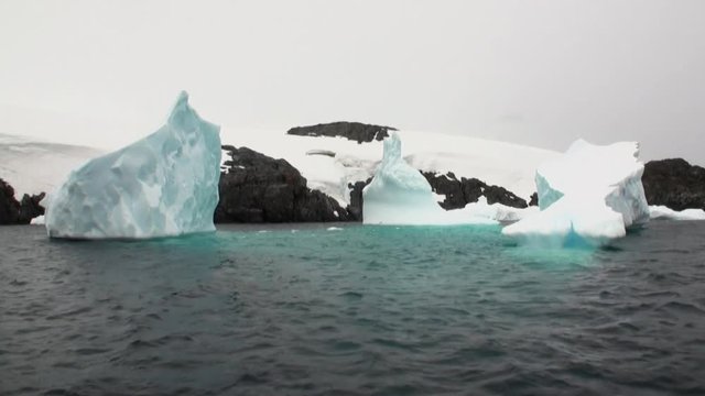Ice movement and snow coastline in ocean of Antarctica. Amazing unique beautiful wilderness nature and landscape of white mountains. Extreme tourism cold desert north pole.