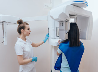 Young woman patient standing in x-ray machine.