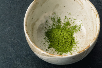 Matcha powder in bowl with Chashaku matcha spoon. Matcha is made of finely ground green tea powder. It's very common in japanese culture. Matcha is healthy due to it's high antioxydant count.