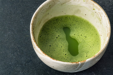 Matcha powder in bowl with Chashaku matcha spoon. Matcha is made of finely ground green tea powder. It's very common in japanese culture. Matcha is healthy due to it's high antioxydant count.