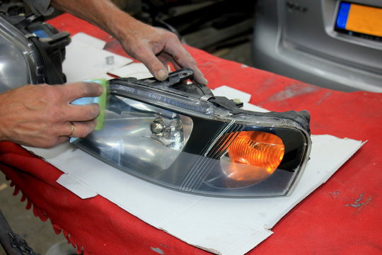 Man refurbishing car headlight