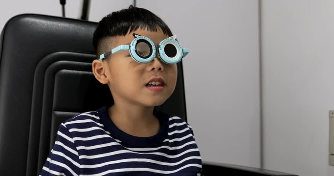 Young boy while undergoing eye test in optical shop