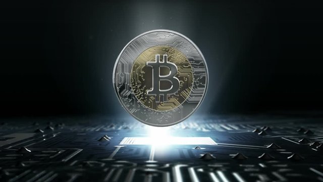 A loopable rotating bitcoin cryptocurrency in hologram form hovvering over a computer circuit board