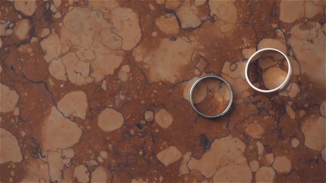 Groom wedding ring rolling and falls near bride's ring