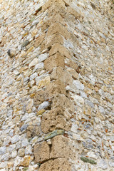 The angle of the wall built of stone (tufa, limestone) and mortar; fence, tower, fortress; background, texture.