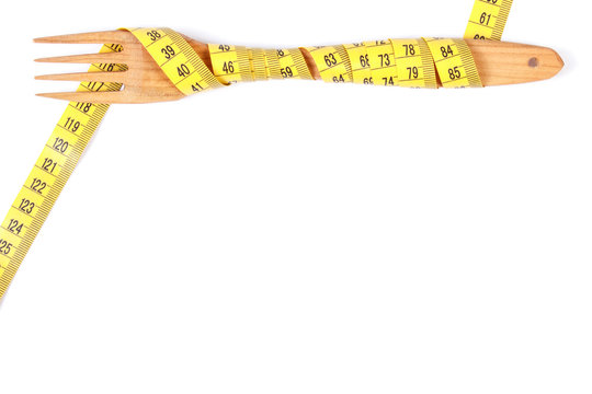 Wooden fork wrapped tape measure, concept of slimming, copy space for text on white