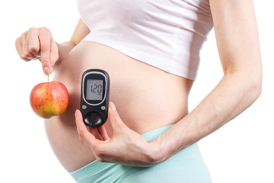 Woman In Pregnant Holding Glucose Meter And Apple, Diabetes And Healthy Nutrition During Pregnancy