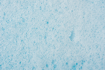 Foam bubble from soap or shampoo washing on blue background top view