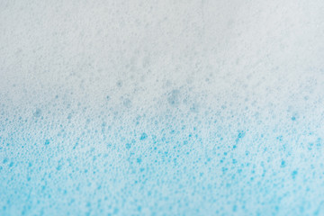 Foam bubble from soap or shampoo washing on blue background top view , focus at center image