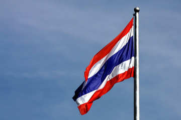 Thai flag waving Thailand with blue sky background.