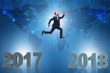 Businessman in santa hat jumping from 2017 to 2018