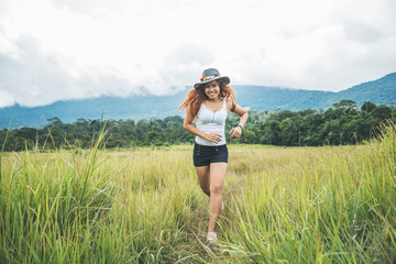 Asian women travel relax in the holiday. on a green pasture.