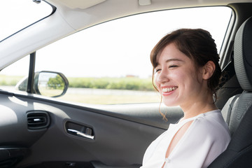 young woman sitting on assistant seat of motor vehicle.