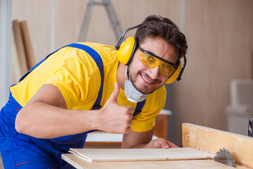 Young repairman carpenter working cutting wood on circular saw