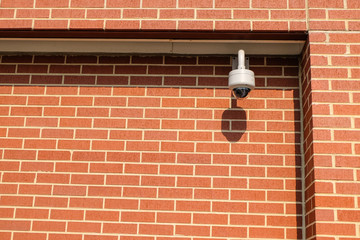 CCTV camera at a red brick wall