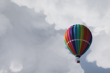 Aerostat floating in day sky. Mixed media