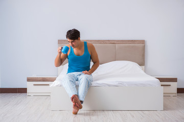 Young man waking up in bed