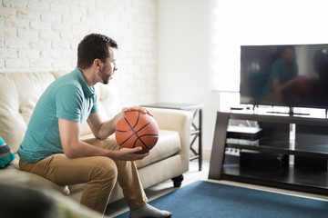 Attractive man watching basketball game